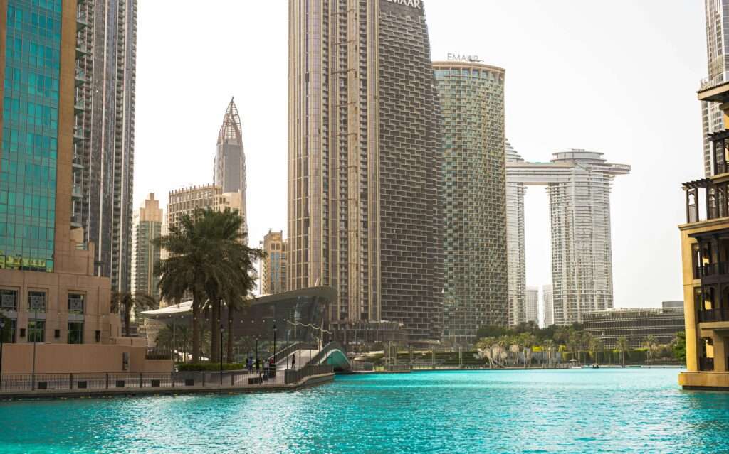 Stunning view of Dubai's modern skyline and vibrant blue water under a clear sky.